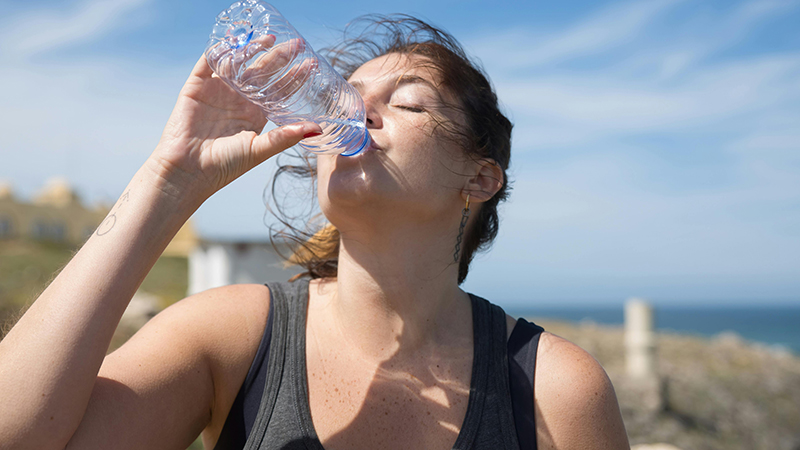 A woman drinking water in the heat