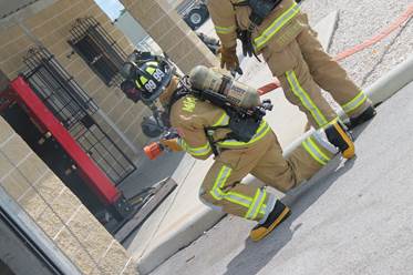 NASCAR driver Carl Edwards (in the No. 99 helmet) battles a house fire during training exercises at Miami-Dade Fire Rescue Headquarters training facility on Wednesday, September 11, 2013.