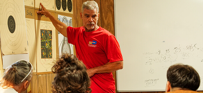 A Trail Glades Range instructor teaching three students.