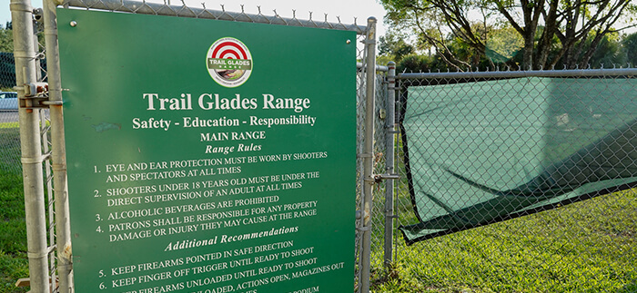 A sign on a fence showing the rules at Trail Glades Range.