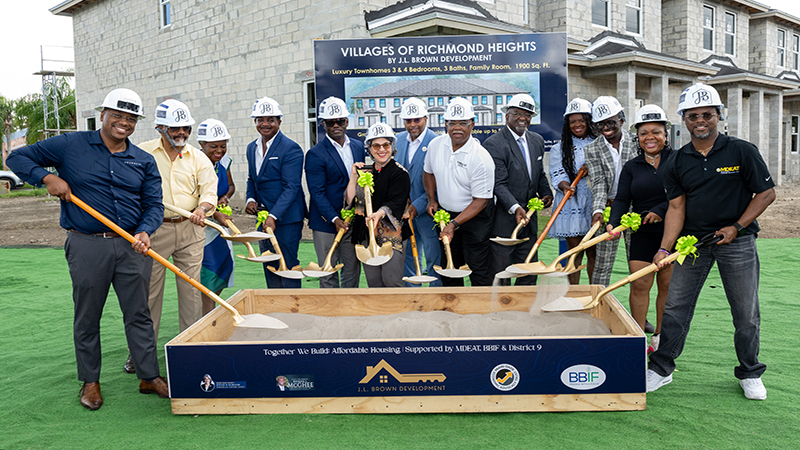 People standing and smiling in front of their new home