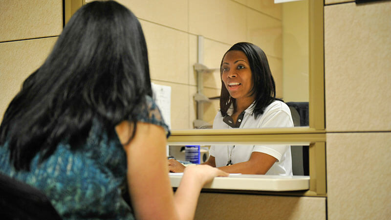 A customer service representative helping someone at a counter.