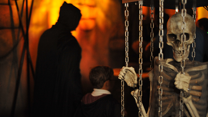 Skeleton with chains and people in the background