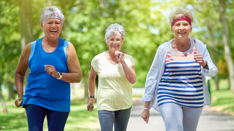 three elderly women power walking